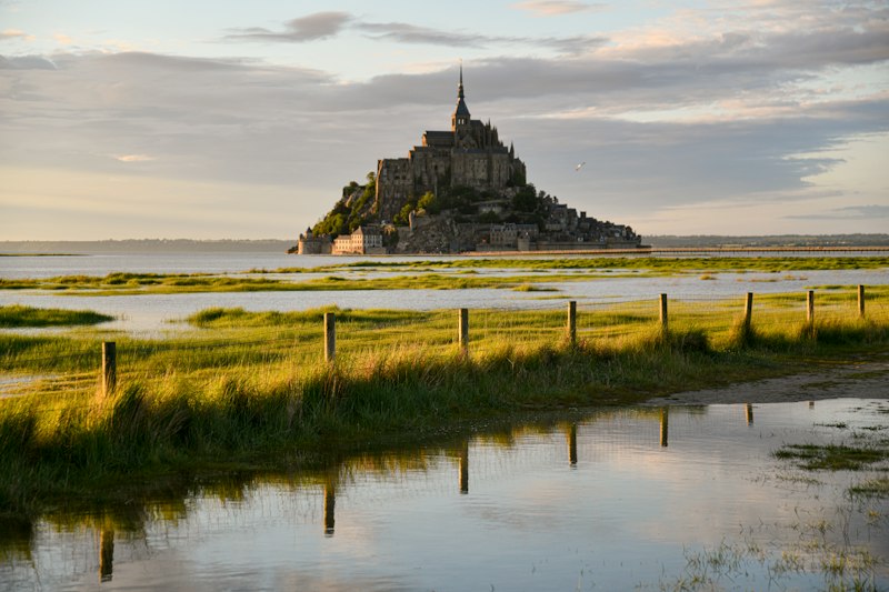 Mont-Saint-Michel at sunset across the tidal flats